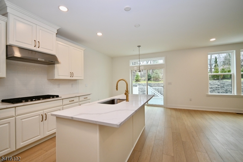 26 Arowana Road Randolph, NJ 07869 - Photo 6 of 26 a kitchen with granite countertop a stove a sink a refrigerator and white cabinets with wooden floor