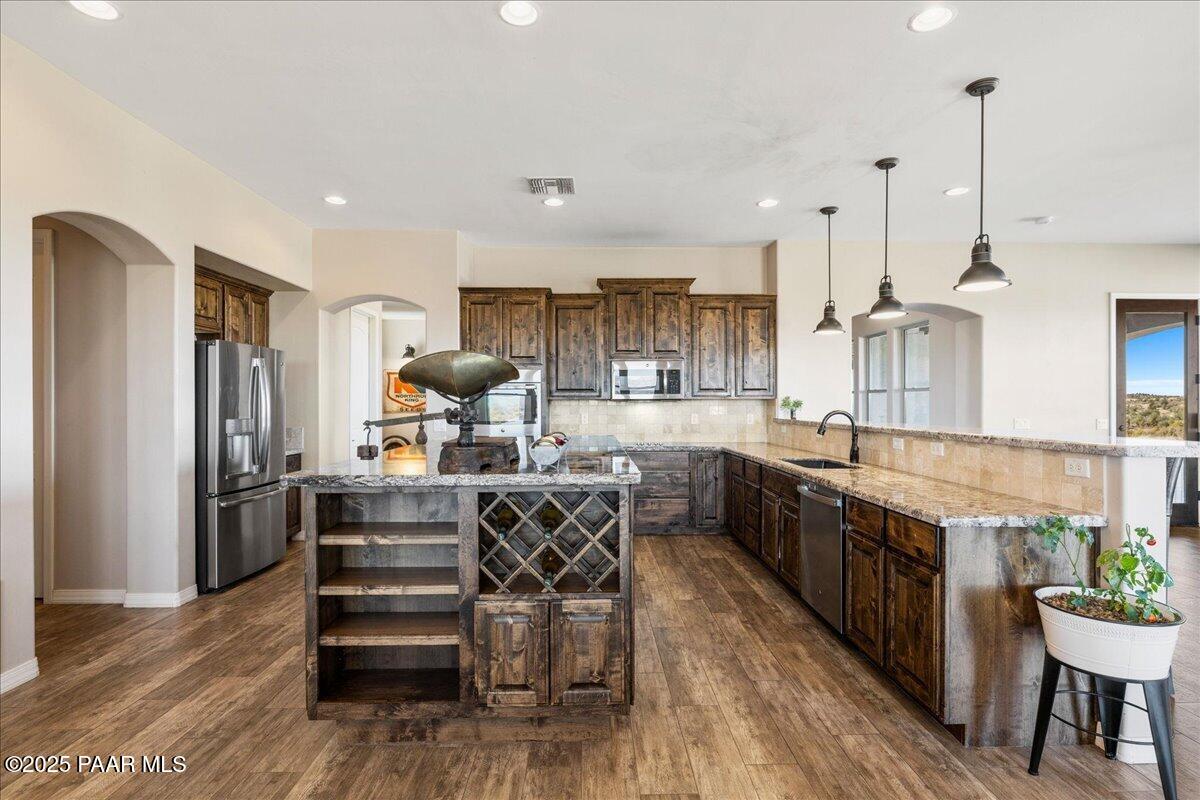 12300 West Slate Road Prescott, AZ 86305 - Photo 14 of 59 a kitchen with stainless steel appliances granite countertop a table chairs stove and kitchen view