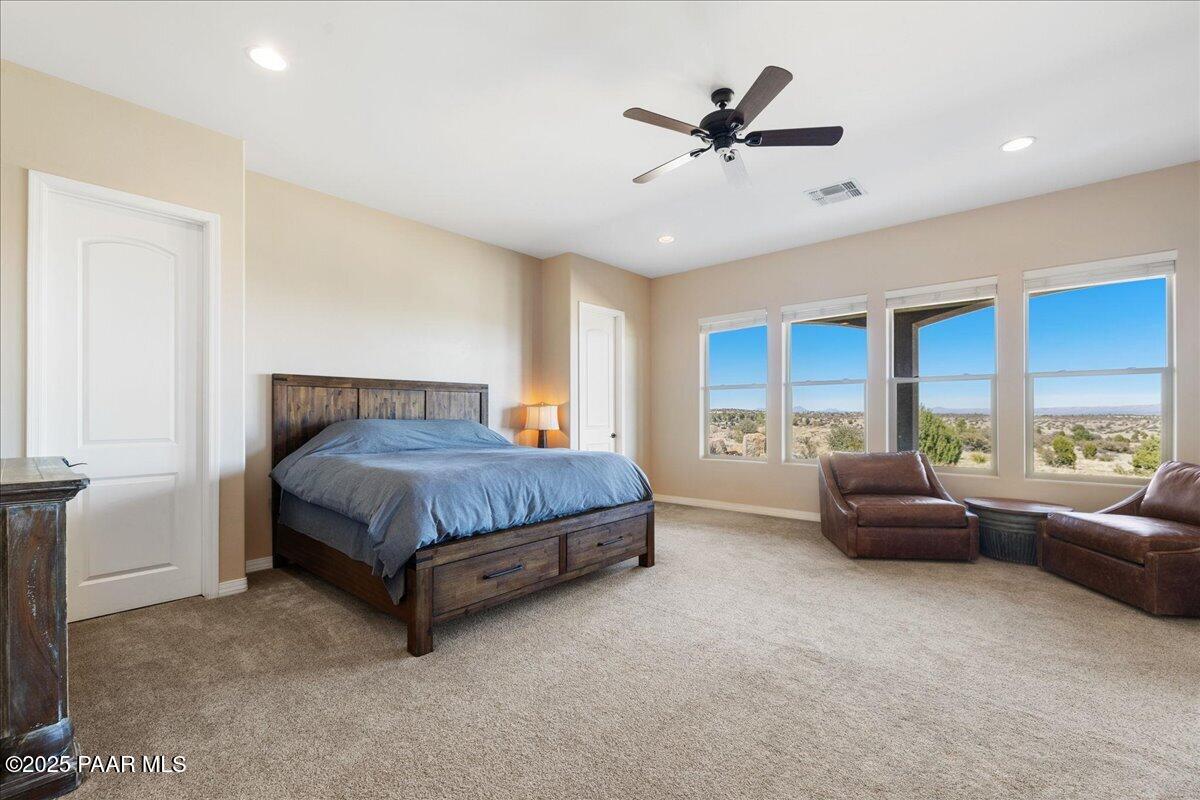 12300 West Slate Road Prescott, AZ 86305 - Photo 18 of 59 a bedroom with a bed a couch and a ceiling fan