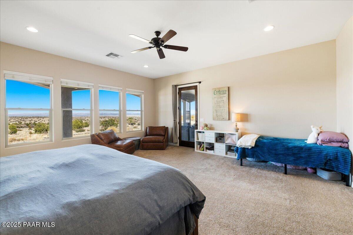 12300 West Slate Road Prescott, AZ 86305 - Photo 19 of 59 a spacious bedroom with a bed a couch and large window