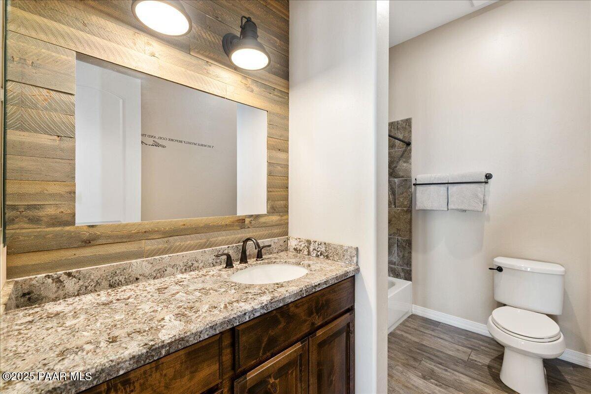 12300 West Slate Road Prescott, AZ 86305 - Photo 23 of 59 a bathroom with a granite countertop sink a toilet and a mirror