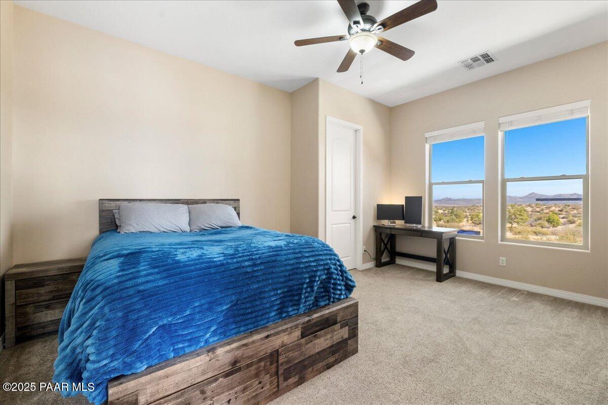 12300 West Slate Road Prescott, AZ 86305 - Photo 24 of 59 a bedroom with a bed and a chandelier