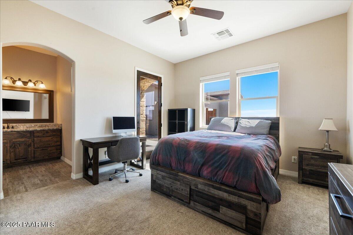 12300 West Slate Road Prescott, AZ 86305 - Photo 28 of 59 a spacious bedroom with a bed and a chandelier