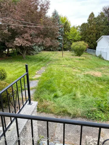 a view of a bench in backyard of a house
