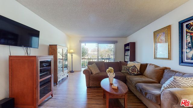 a living room with furniture flat screen tv and a large window