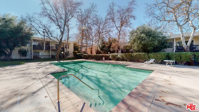 a view of a yard with plants and trees