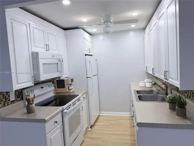 a kitchen that has a sink a stove and a microwave