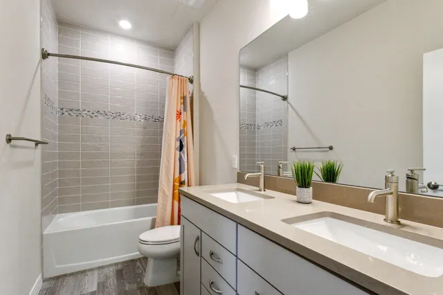 a bathroom with a granite countertop sink toilet and shower