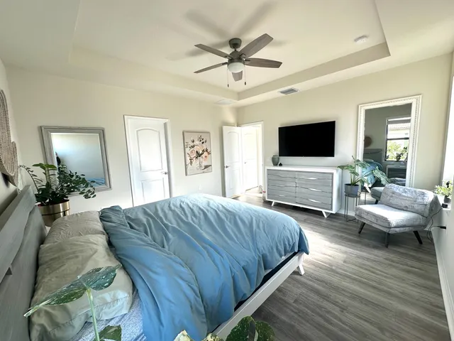 a spacious bedroom with a bed and a flat screen tv