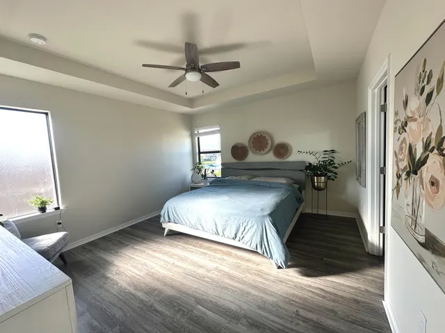 a bedroom with a bed wooden floor and ceiling fan