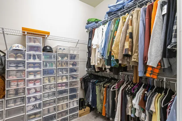 a view of walk in closet with clothes and shoes