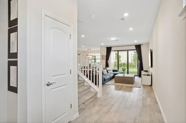a view of a hallway with wooden floor and furniture