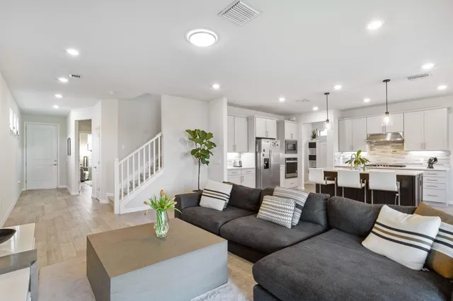 a living room with furniture kitchen and a table