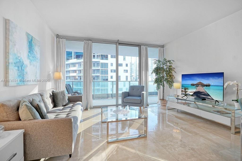 1331 Brickell Bay Drive, Unit 906 Miami, FL 33131 - Photo 2 of 13 a living room with furniture and a floor to ceiling window