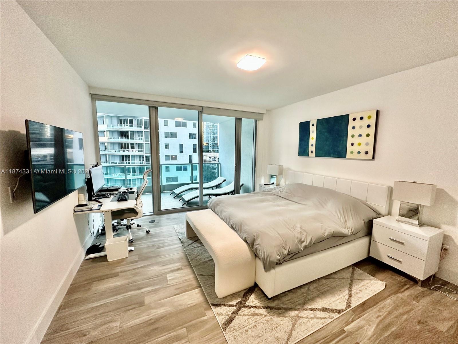 1331 Brickell Bay Drive, Unit 906 Miami, FL 33131 - Photo 6 of 13 a spacious bedroom with a bed and a flat screen tv