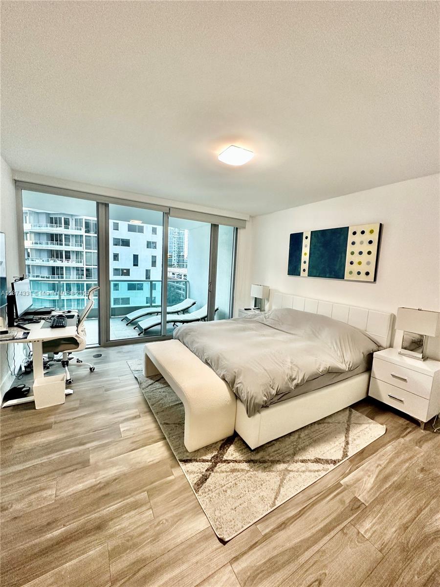 1331 Brickell Bay Drive, Unit 906 Miami, FL 33131 - Photo 7 of 13 a spacious bedroom with a bed couch and a large window
