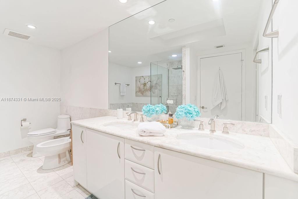 1331 Brickell Bay Drive, Unit 906 Miami, FL 33131 - Photo 9 of 13 a bathroom with a granite countertop sink mirror and a toilet