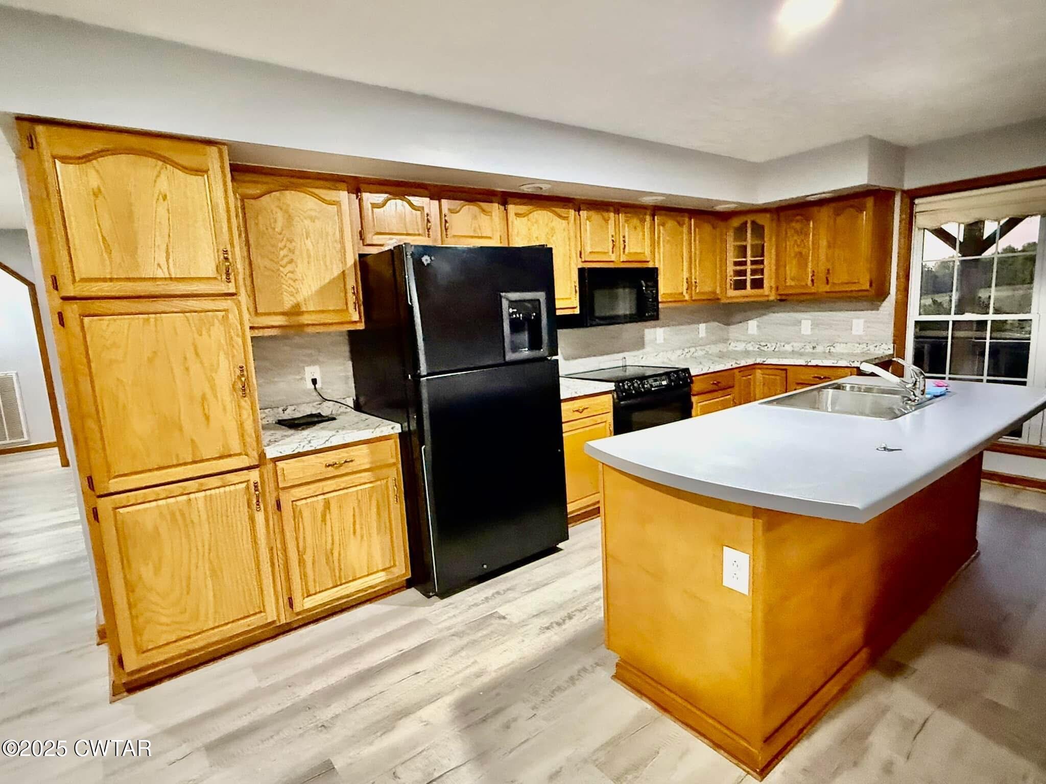 1559 Ella Groom Road Troy, TN 38260 - Photo 14 of 23 a kitchen with stainless steel appliances granite countertop a refrigerator a sink dishwasher a stove and a dining table with wooden cabinet