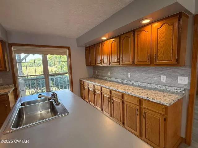 a kitchen with stainless steel appliances granite countertop a sink and a granite counter tops with a large window