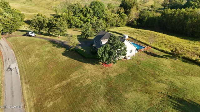a view of yard with swimming pool and trees in the background