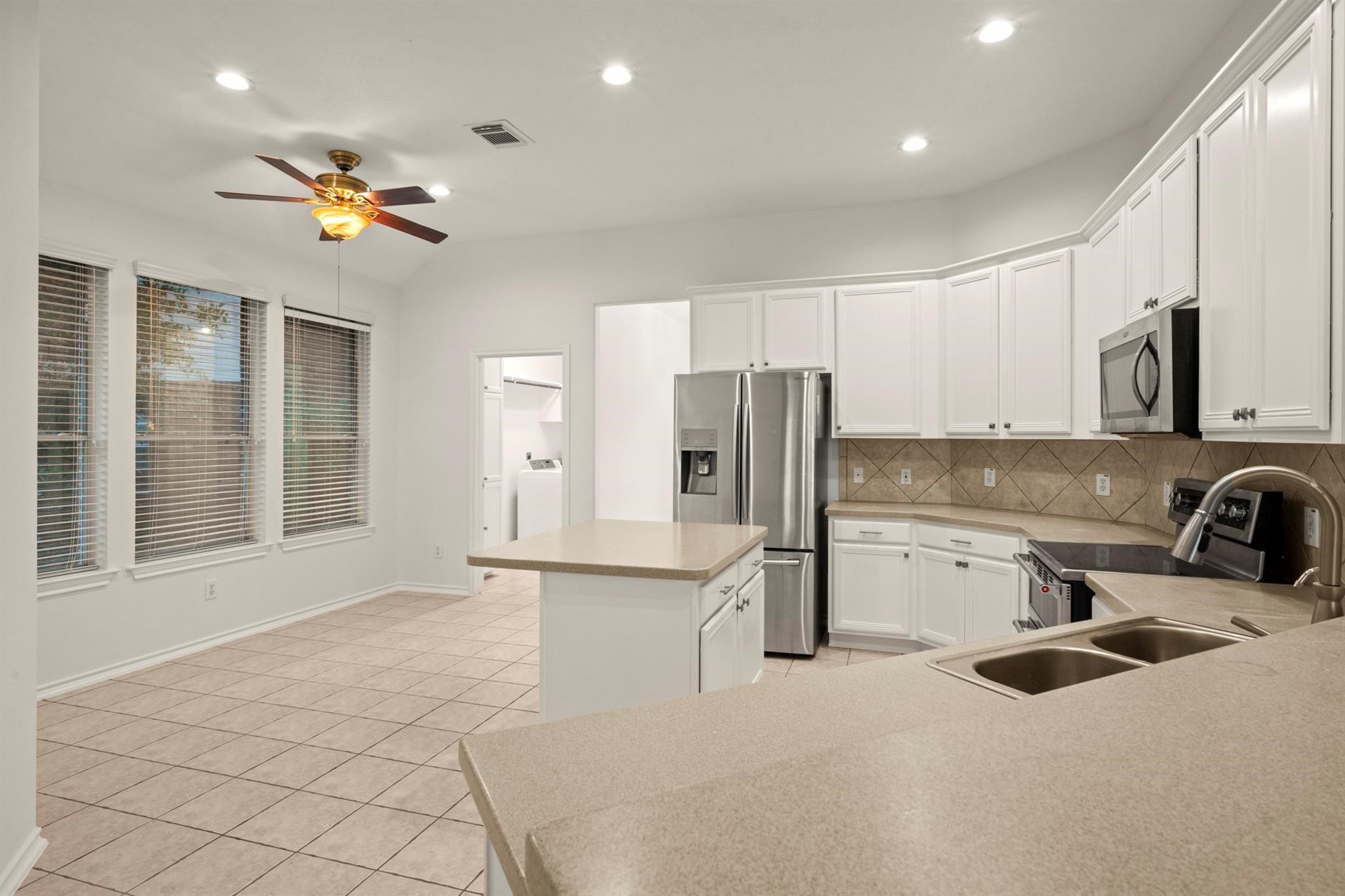 21014 Jessica Rose Lane Spring, TX 77379 - Photo 12 of 30 a kitchen with stainless steel appliances a refrigerator sink and stove