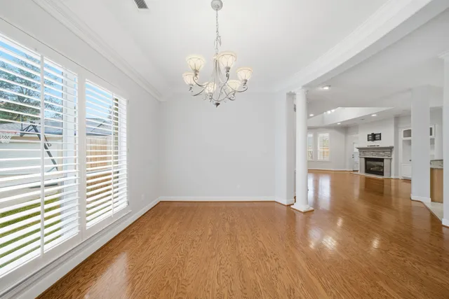a view of a livingroom with a chandelier furniture and wooden floor