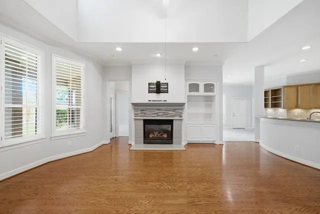 a view of a livingroom with a fireplace window and wooden floor