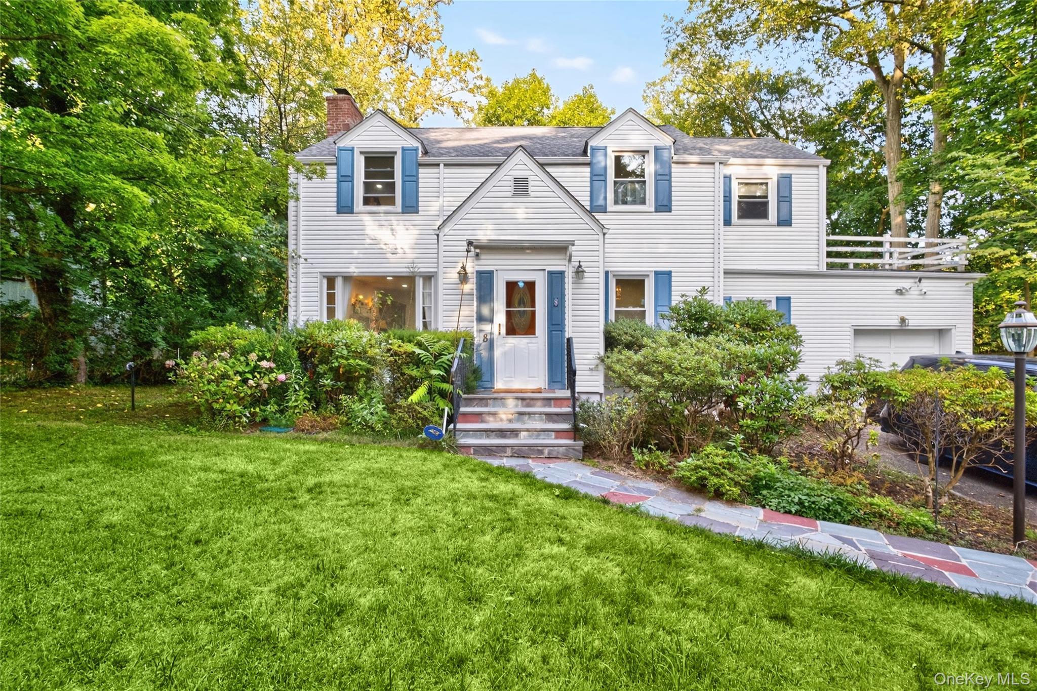8 Beechwood Road Hartsdale, NY 10530 - Photo 1 of 1 View of front of property featuring a chimney, a front lawn, and an attached garage