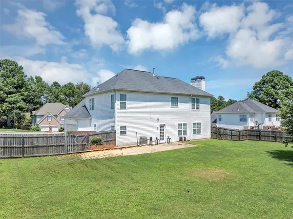 a view of a house with a big yard and sitting area