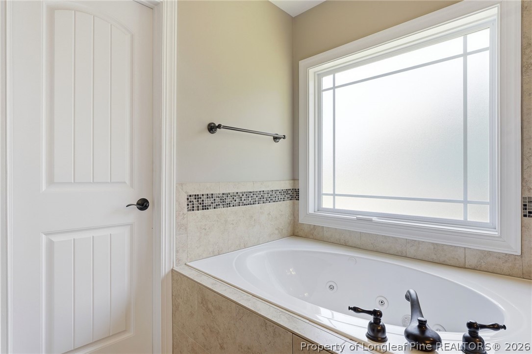 886 Micahs Way North Spring Lake, NC 28390 - Photo 23 of 50 a bathroom with a tub and a shower