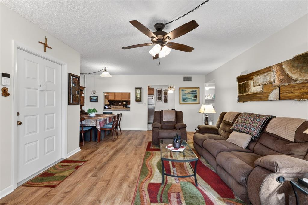 1258 Pine Ridge Circle West, Unit D1 Tarpon Springs, FL 34688 - Photo 15 of 42 a living room with furniture a ceiling fan and a rug