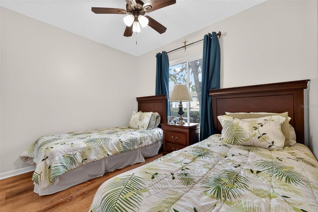 1258 Pine Ridge Circle West, Unit D1 Tarpon Springs, FL 34688 - Photo 24 of 42 a bedroom with two beds and a chandelier