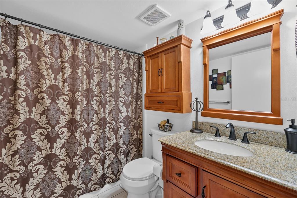 1258 Pine Ridge Circle West, Unit D1 Tarpon Springs, FL 34688 - Photo 25 of 42 a bathroom with a granite countertop sink and a mirror