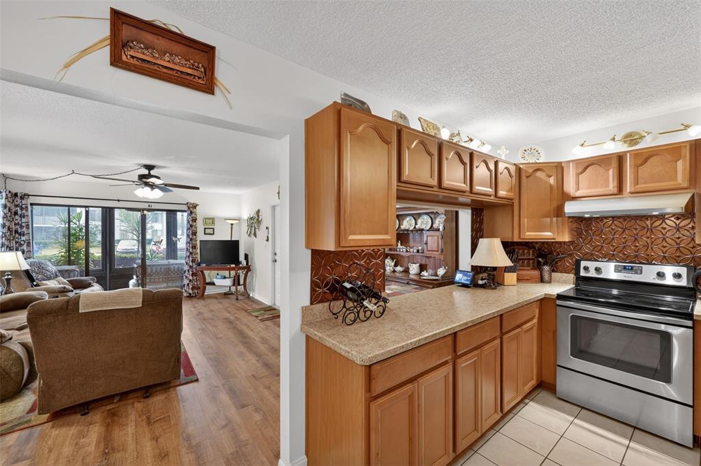 1258 Pine Ridge Circle West, Unit D1 Tarpon Springs, FL 34688 - Photo 7 of 42 a kitchen with stainless steel appliances granite countertop a stove a sink and a refrigerator
