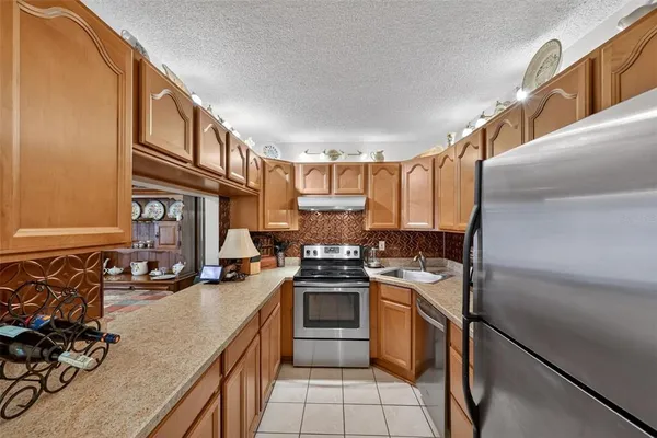 a kitchen with stainless steel appliances granite countertop a refrigerator sink and stove