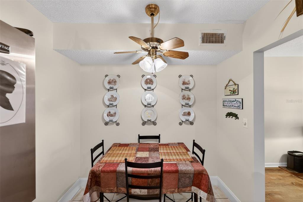 1258 Pine Ridge Circle West, Unit D1 Tarpon Springs, FL 34688 - Photo 10 of 42 a room with a chandelier fan and a wooden floor