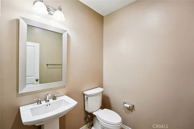 a bathroom with a toilet a sink and mirror