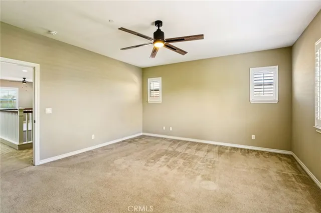 an empty room with ceiling fan and window
