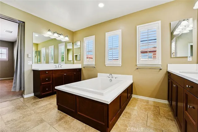 a spacious bathroom with a tub sink and mirror
