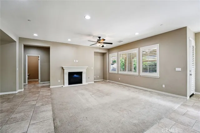a view of an empty room with a window and fireplace
