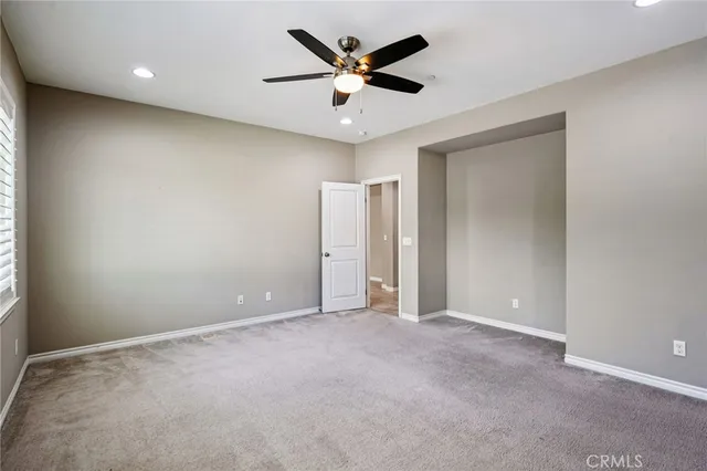 an empty room with closet and a ceiling fan
