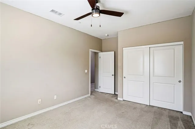 an empty room with chandelier fan