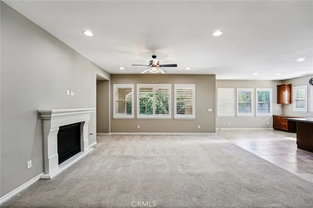 a view of an empty room with window and fire place