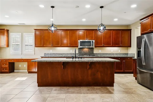 a kitchen with stainless steel appliances granite countertop a sink refrigerator and microwave