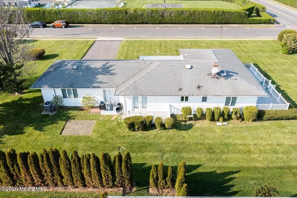 a front view of a house with a garden and lake view
