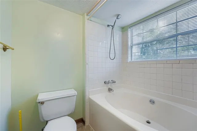 a white toilet sitting next to a bath tub and shower