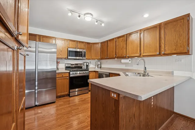 a kitchen with stainless steel appliances granite countertop a sink stove and refrigerator