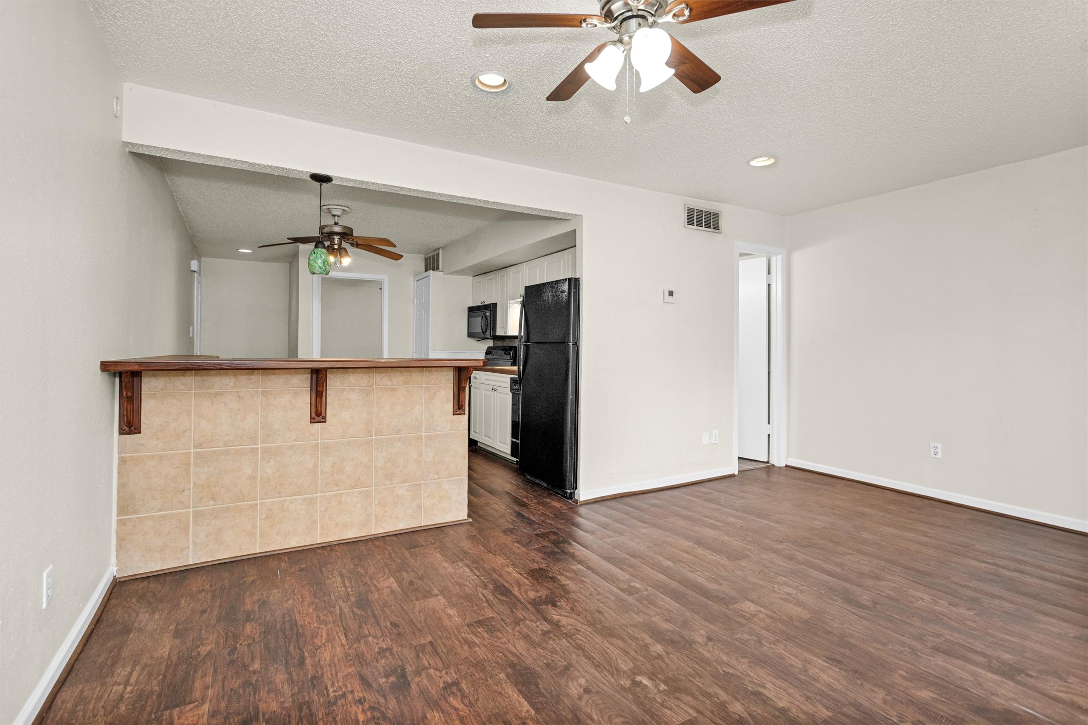 12900 Walden Road, Unit 513 Montgomery, TX 77356 - Photo 5 of 20 wooden floor in an empty room with a kitchen