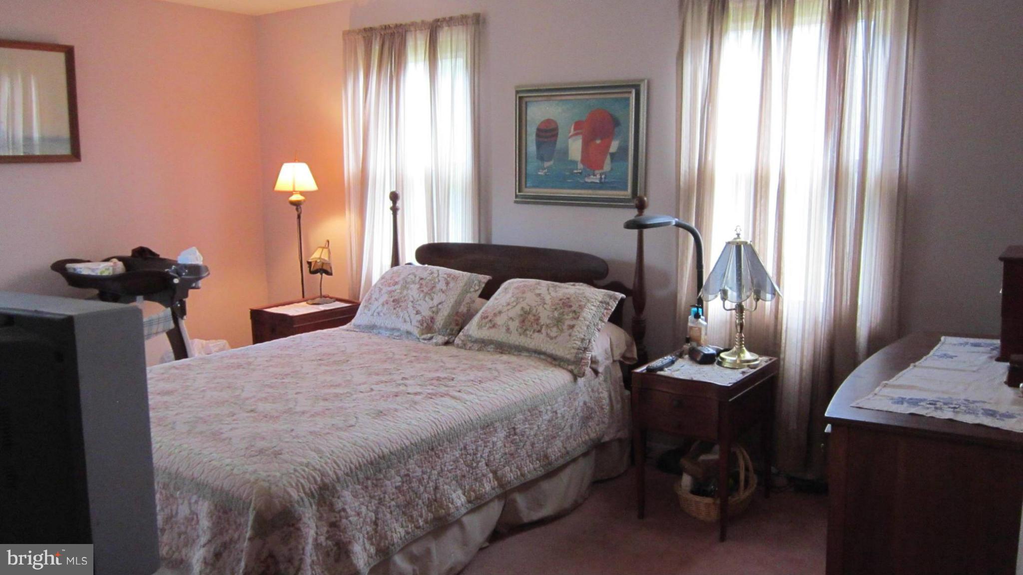 17030 Hughes Road Poolesville, MD 20837 - Photo 12 of 24 a bedroom with a bed and a chandelier