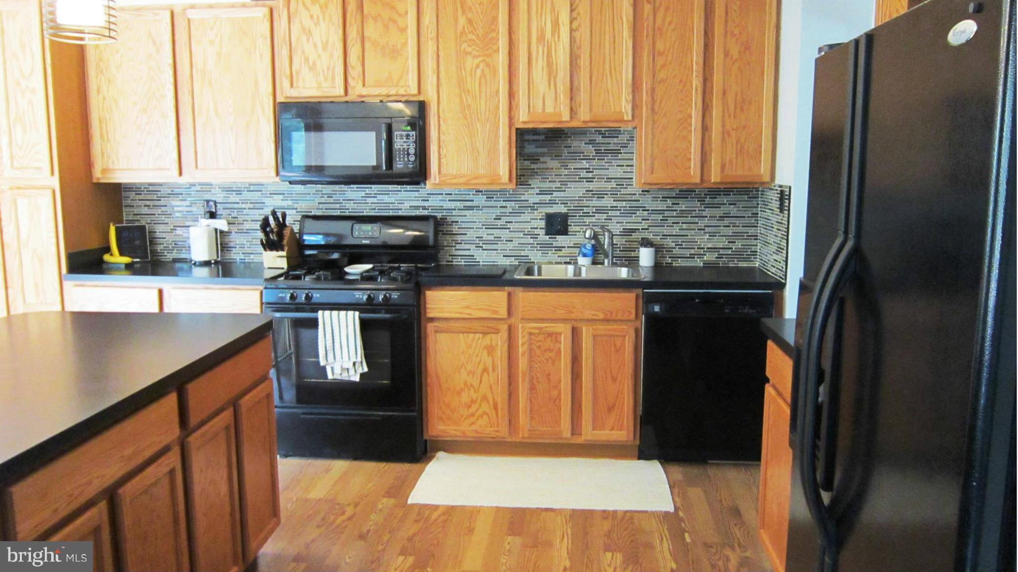 17030 Hughes Road Poolesville, MD 20837 - Photo 4 of 24 a kitchen with stainless steel appliances granite countertop a refrigerator a sink and a stove